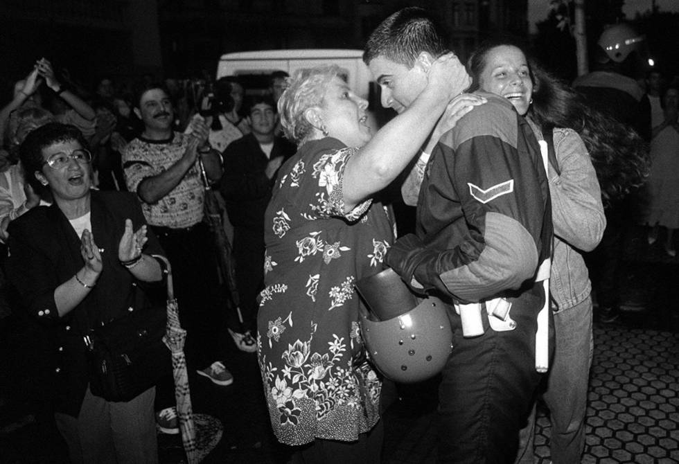 A woman hugs a member of the Basque regional police (Ertzaintza) who has removed his head gear and is showing his face during the unrest in Ermua.