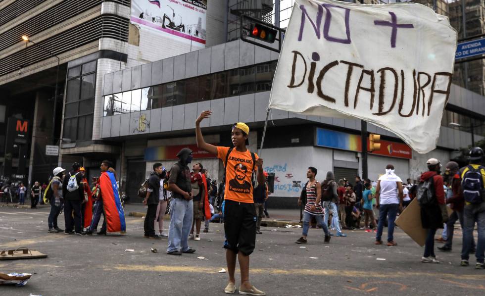 Manifestantes opositores bloquean en Caracas una vía durante una protesta del 18 de julio.