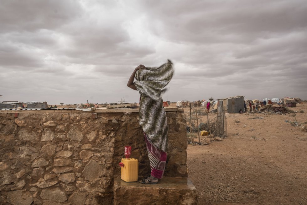 Na Somália a água é um bem primordial, mas em alguns lugares é preciso escavar poços de até 400 metros de profundidade para poder encontrá-la. Na imagem, uma mulher luta contra o vento no campo de refugiados de Hodo, norte do país.