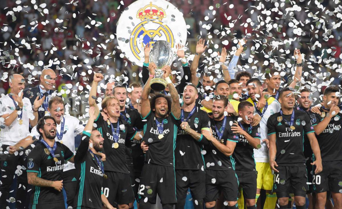 Los jugadores del Madrid levantan el trofeo.