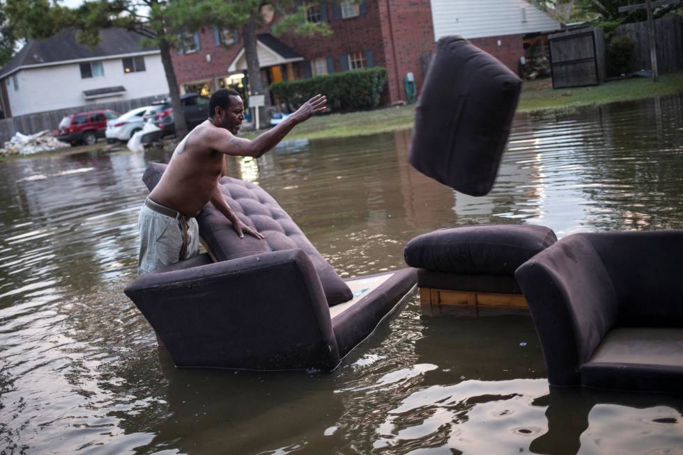Vince Ware traslada sus sofás desde su casa inundada en Houston, Texas.