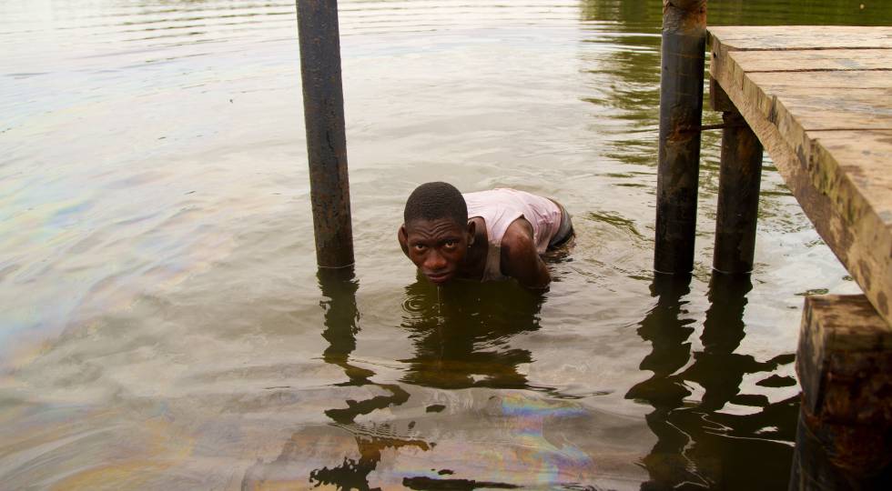 Un pescador del Delta del Níger, en Nigeria, sumergido en aguas contaminadas por vertidos de petróleo.