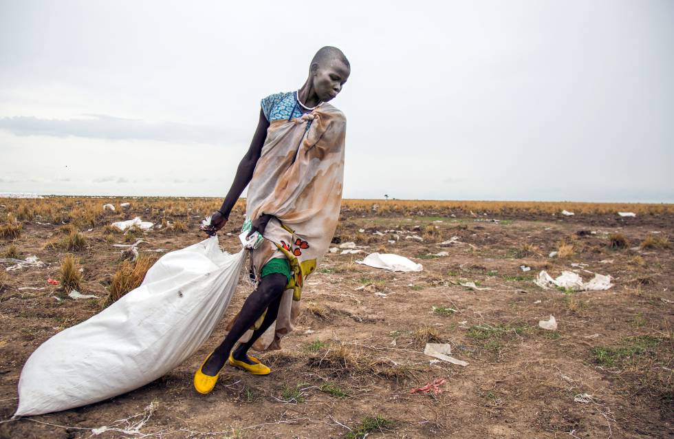 Una mujer arrastra un saco de comida lanzado desde el aire por el Programa Mundial de Alimentos en Ganyiel (Sudán del Sur).