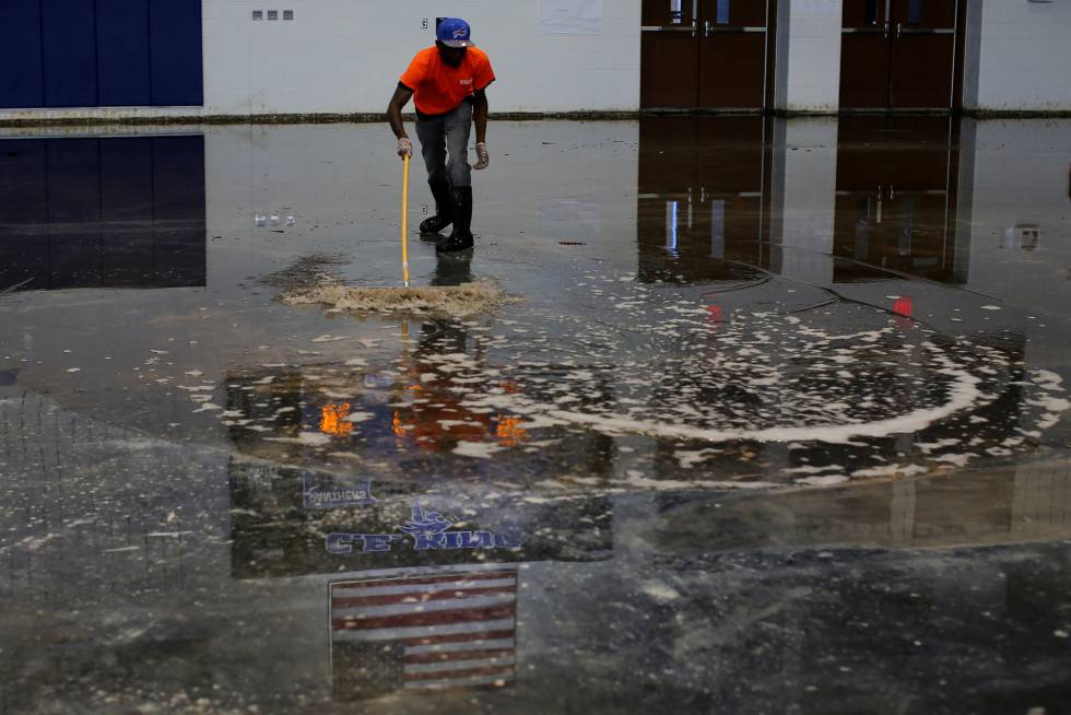 Un trabajador aparta el agua de un gimnasio en Houston, Texas, tras el paso de la tormenta Harvey.