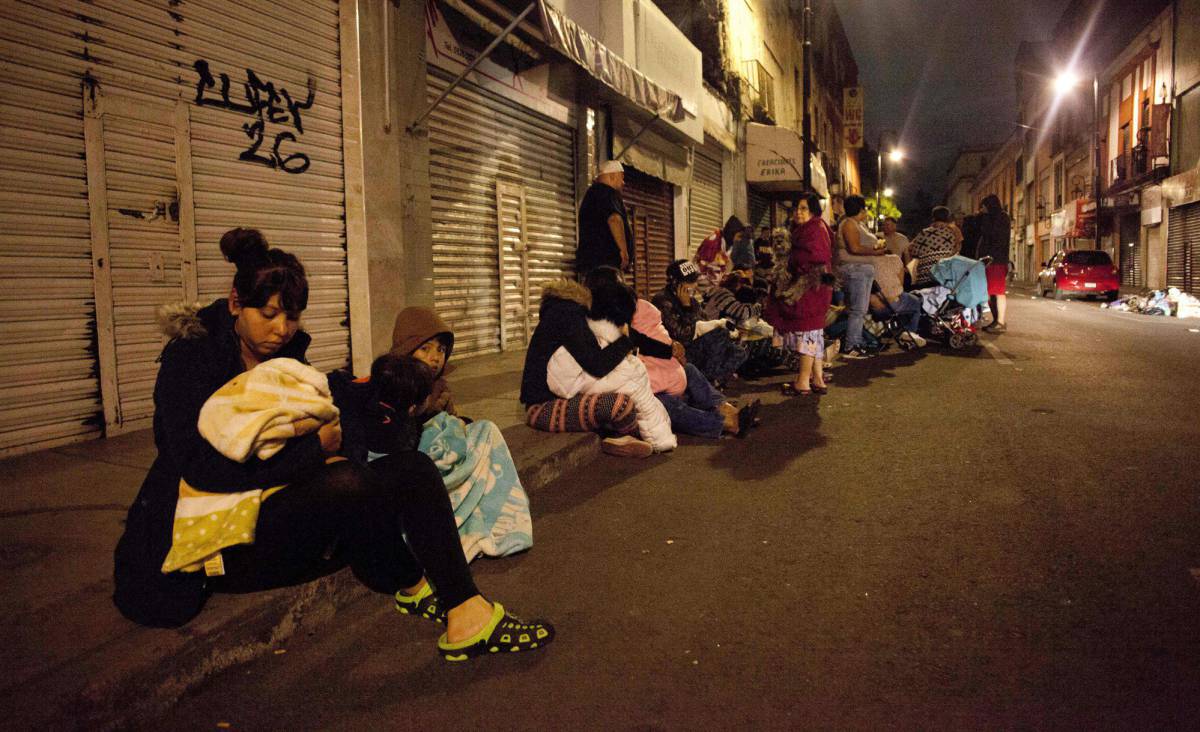 Varias personas esperan en una calle de la Ciudad de México tras el temblor.