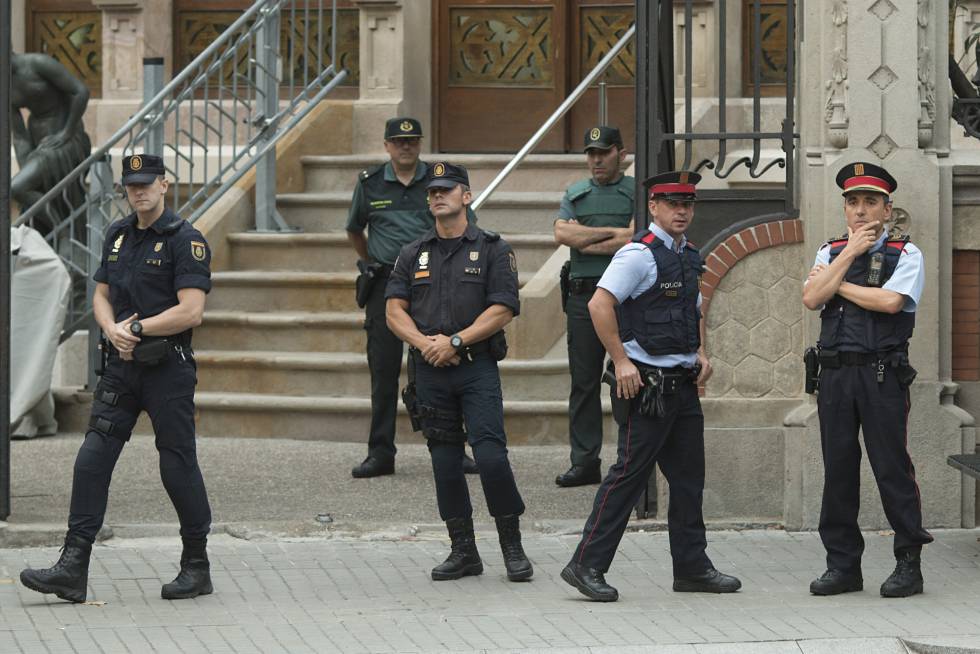 Miembros de la Guardia Civil, de la Policía Nacional y de los Mossos d'esquadra en la puerta de la Delegación del Gobierno en Barcelona.