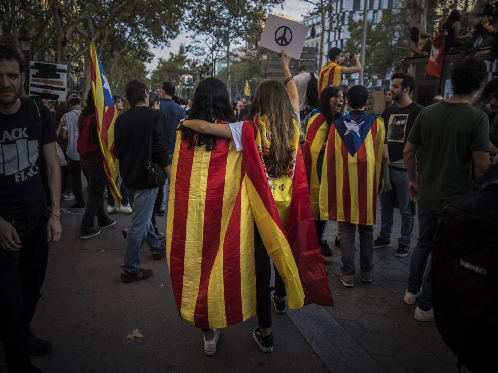 Dos chicas, una con la bandera independentista catalana, la otra con la bandera española, se manifiestan en Barcelona el pasado 3 de octubre en contra de la actuación policial del 1-O. 