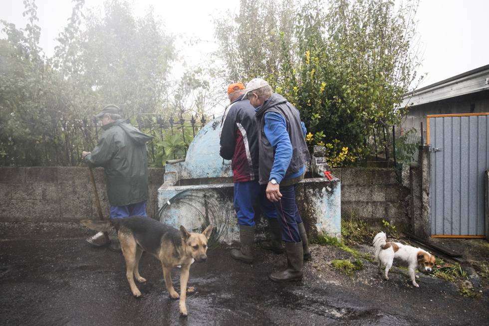Residents of Carballeda de Avia collect water.
