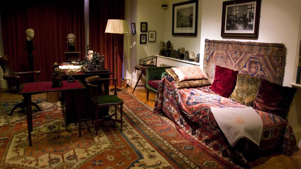 Estudio de Sigmund Freud con el diván cubierto con una alfombra en primer plano, en su casa de Londres.