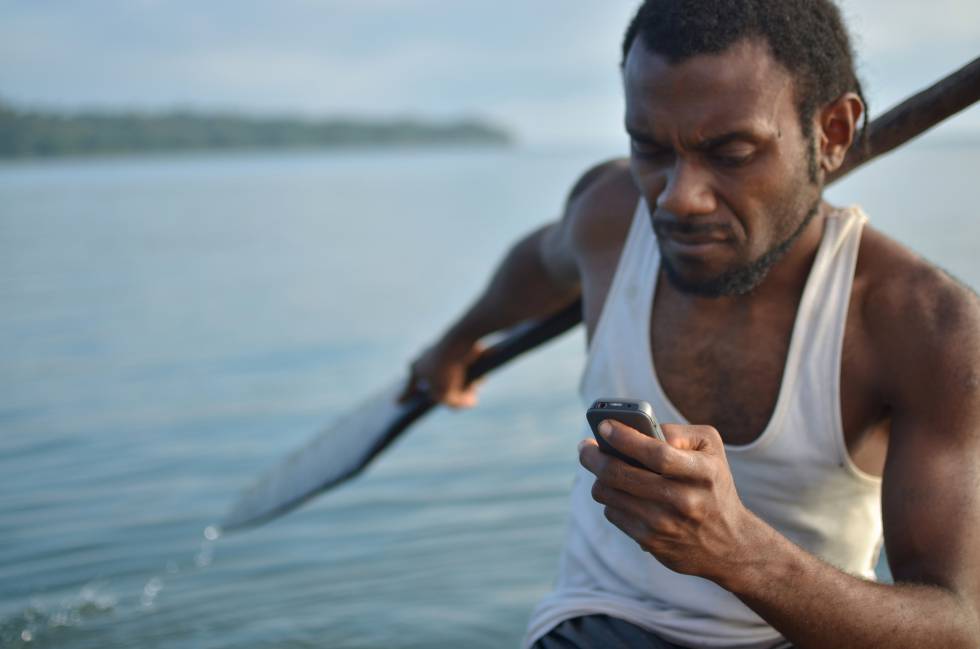 Kelan Sing, un pescador de una isla de Vanuatu, con un teléfono móvil que le permite pedir ayuda mientras faena.