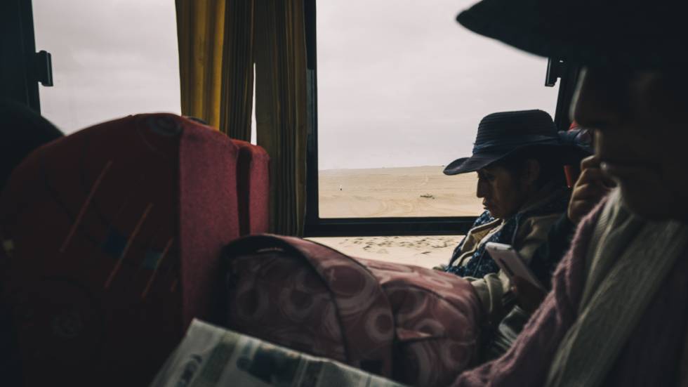 Pasajeros leen periódicos en el autobús que cruza la frontera y conecta la ciudad peruana de Tacna con la primera ciudad chilena, Arica.