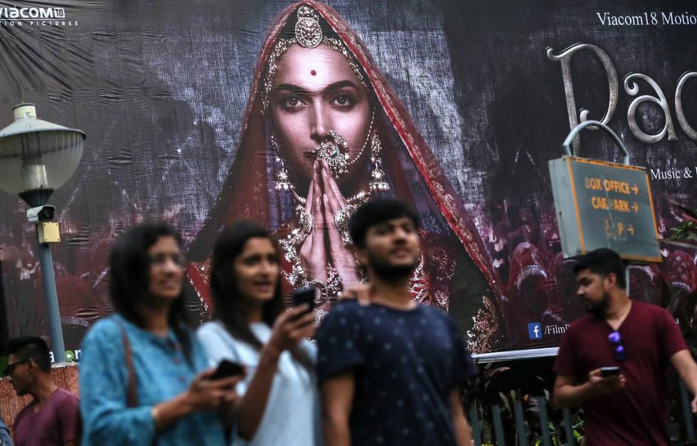 Varias personas pasan por delante de un cartel publicitario de la película 'Padmavati' en Bombay.