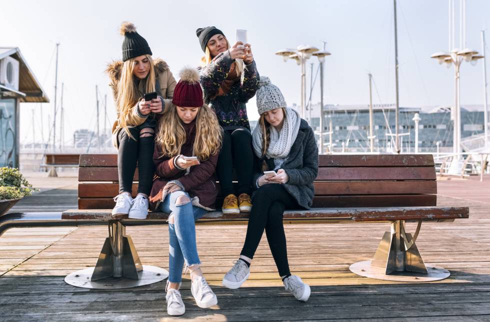 Unas jóvenes con sus teléfonos móviles.