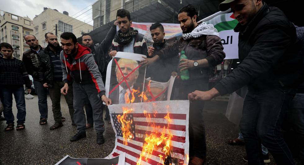 Varios palestinos queman banderas  de EE UU y fotos de Trump.