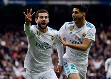 Real Madrid's Spanish defender Nacho Fernandez celebrates with Real Madrid's Spanish midfielder Marco Asensio (R) after scoring a goal during the Spanish league football match between Real Madrid and Sevilla at the Santiago Bernabeu Stadium in Madrid on December 9, 2017. AFP PHOTO PIERRE-PHILIPPE MARCOU
