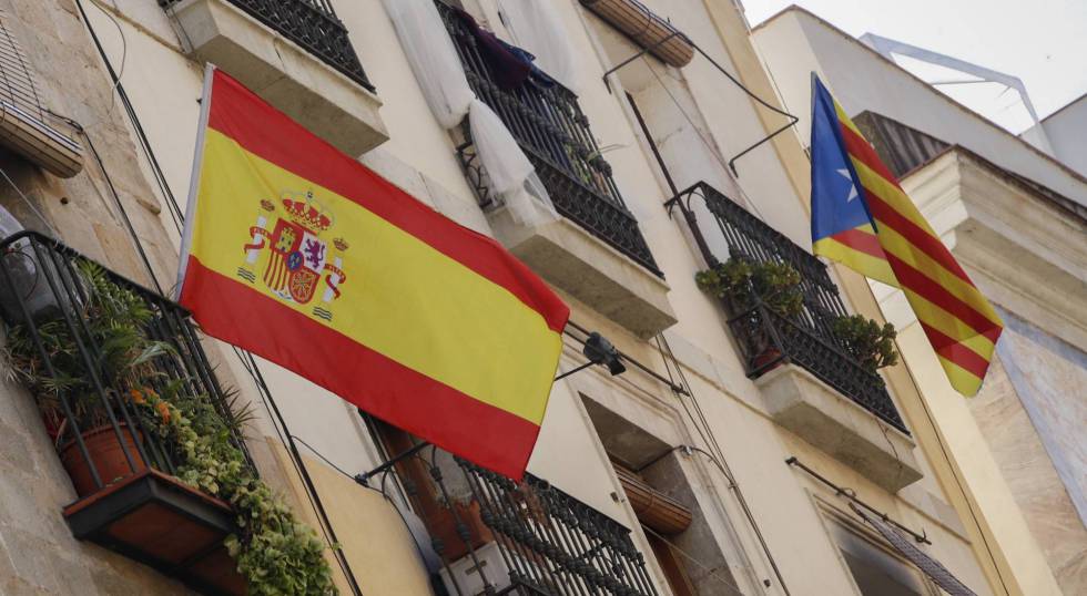 Bandera española y bandera catalana estelada independentista en un edificio de Barcelona.