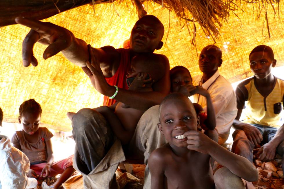 Sylvin Boda señala con el dedo junto a varios de sus vecinos y algunos de sus hijos, en Betare-Oya (Camerún).