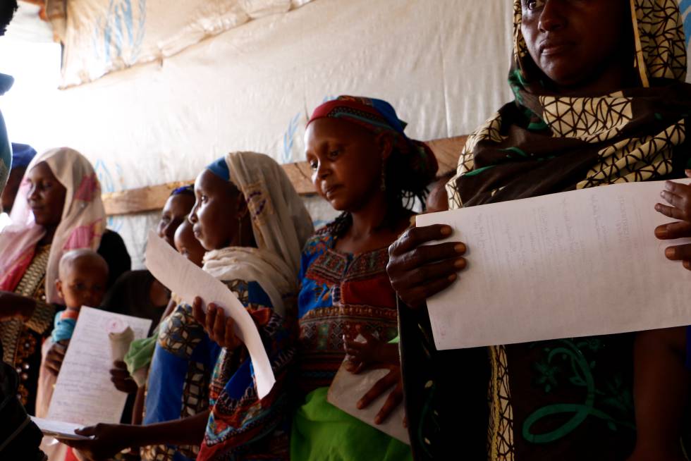 Las madres centroafricanas miran los certificados de nacimiento que las autoridades camerunesas han entregado a sus hijos en el campo de Lolo (Camerún).