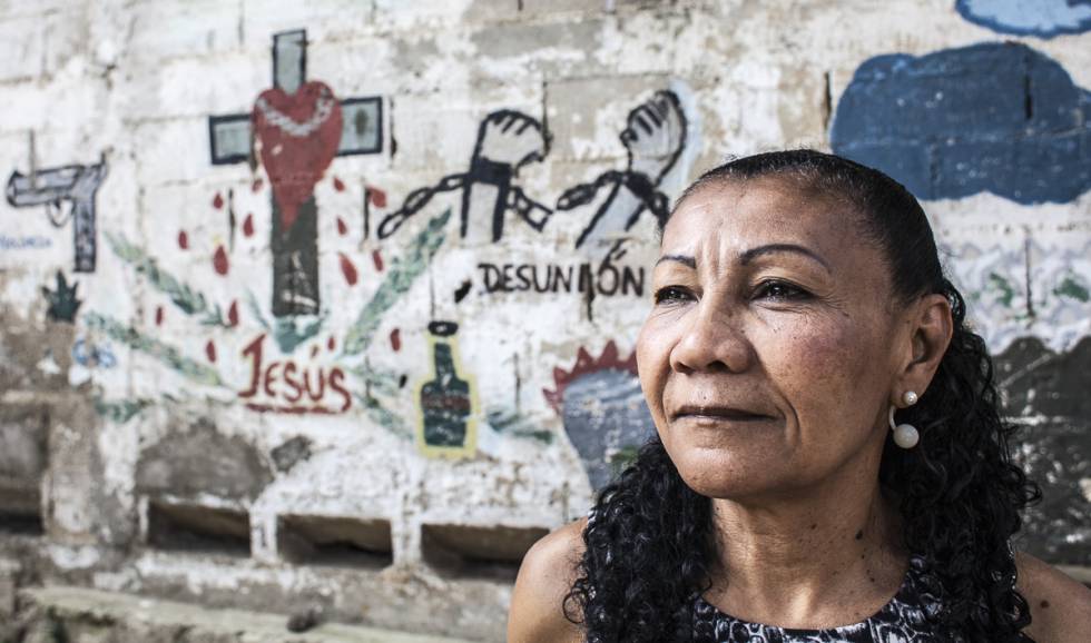 Doris Barrento posa ante el mural que los pandilleros realizaron cuando la firma del acuerdo de convivencia en el barrio de Catuche (Caracas, Venezuela).