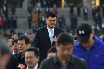 La exestrella de la NBA Yao Ming, rodeado de compatriotas (con pelo), camino del Congreso Nacional durante unas conferencias políticas en Pekín, en marzo de 2017.