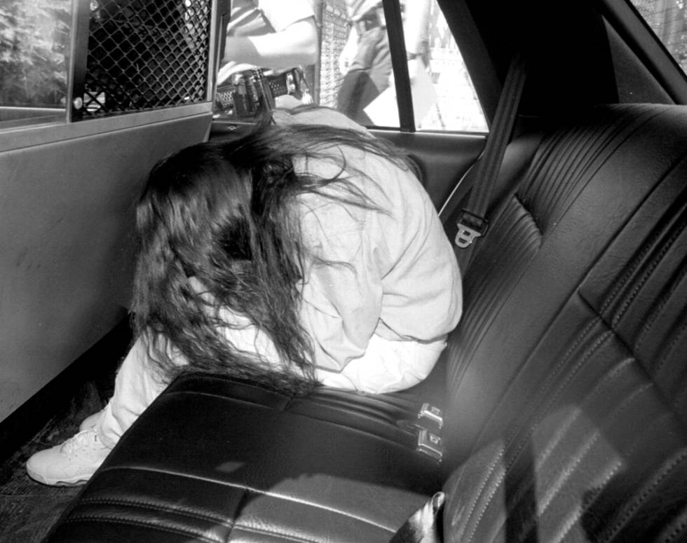 Amy Fisher oculta su rostro de la prensa en un coche de policía en junio de 1992.