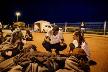Uno de los mediadores culturales de MSF, Guebré Ibrahim Cissé, y la  psicóloga de la organización Rosanna Iacono prestan los primeros auxilios psicológicos en el muelle de Trapani, en Sicilia (Italia) en octubre de 2016.