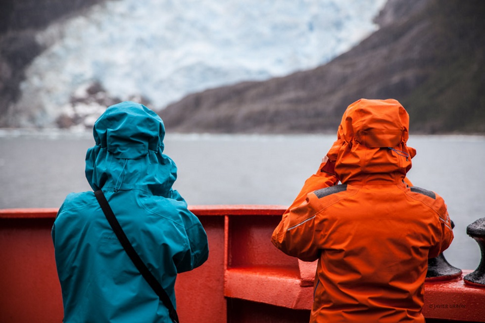 Dos de los científicos que viajan en el 'Hespérides' observan desde la proa del barco un glaciar patagónico.