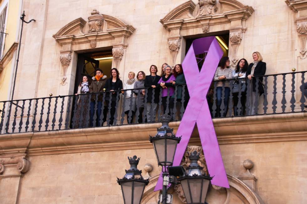 Un lazo morada en la fachada del Ayuntamiento de Palma en apoyo al Día de la Mujer.