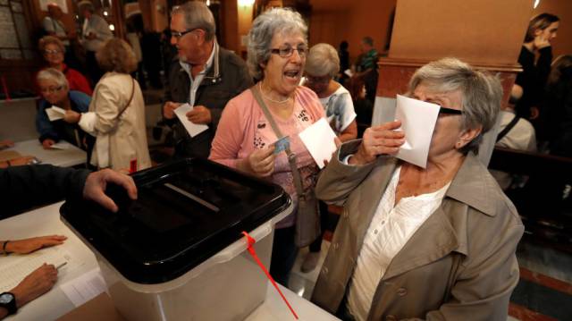 Una mujer besa su papeleta en el referéndum.