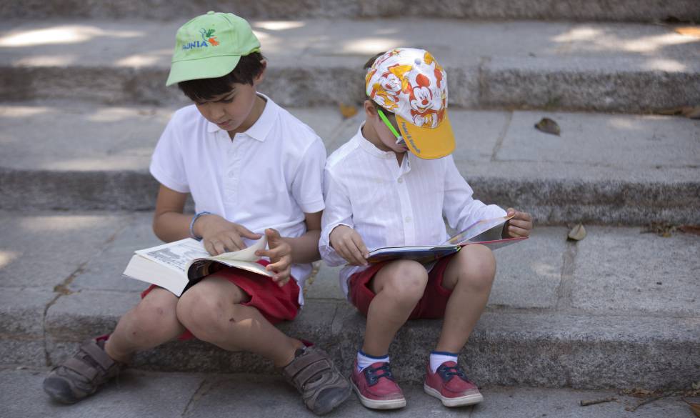 Dos niños leen en la Feria del Libro de Madrid.