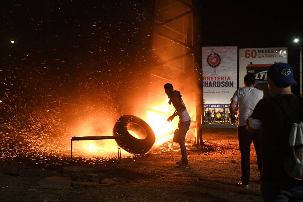 Un profesor lanza un neumático ardiendo contra uno de los árboles artificiales colocados por el Gobierno sandinista en Managua.