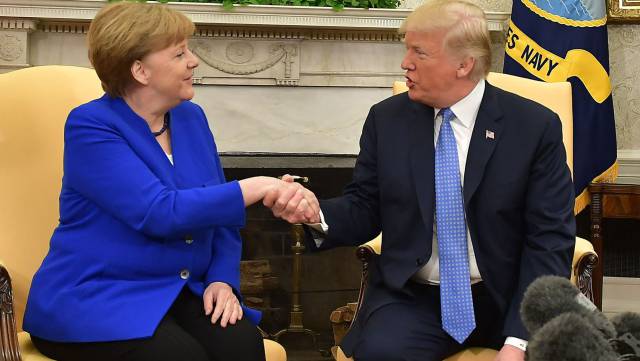 Trump estrecha la mano de Merkel.