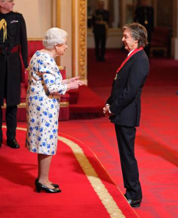 Sir Paul McCartney recibe su condecoración de manos de Isbael II.