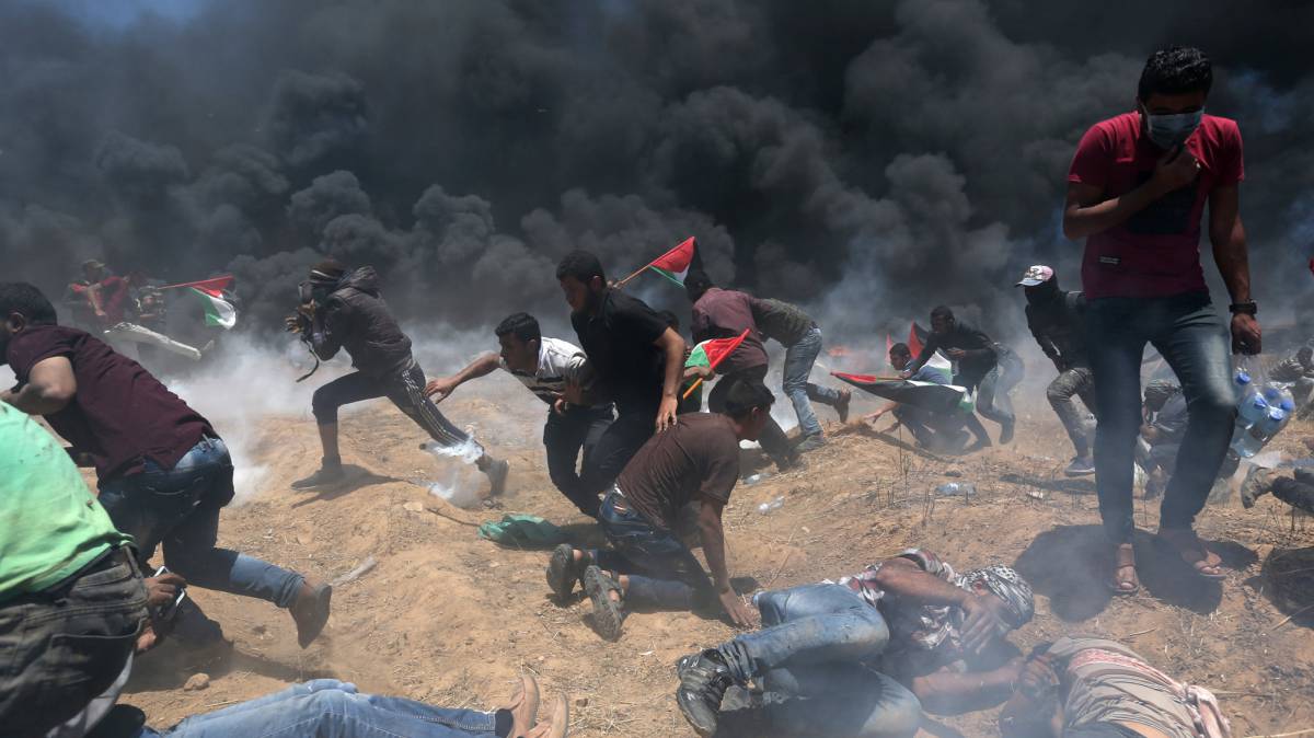 Manifestantes palestinos intentan refugiarse de los disparos del Ejército israelí ayer en Gaza.