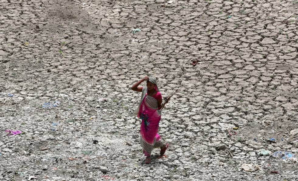 Una mujer camina por una zona seca del rÃ­o Sabarmati, en un caluroso dÃ­a en Ahmedabad (India).