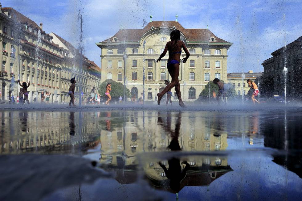 Los niños juegan en la fuente de la plaza del Parlamento.