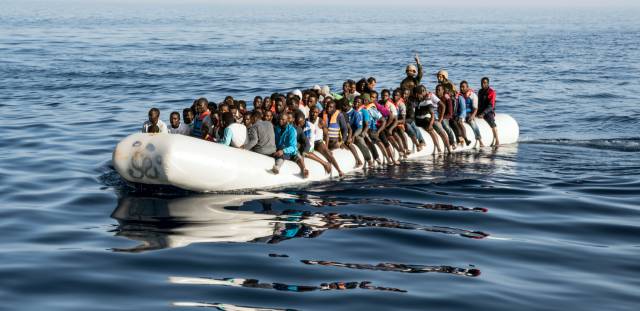 Dos guardias costeros libios en una embarcación de migrantes.