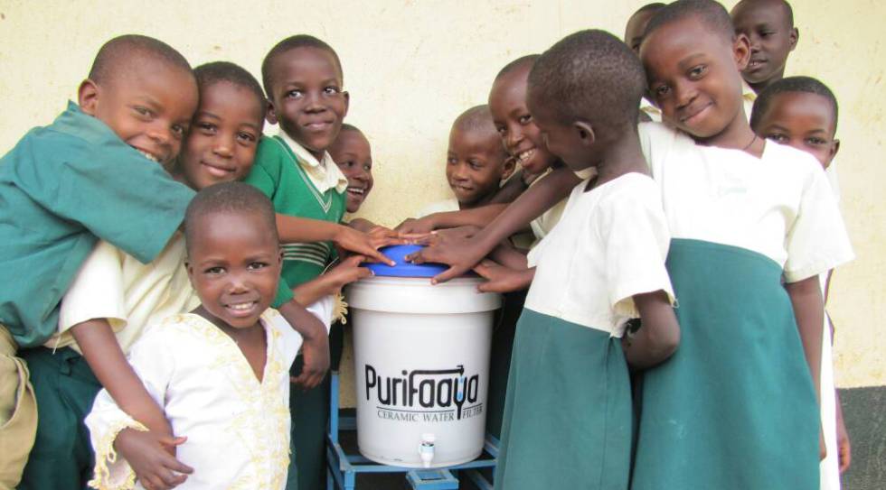 NiÃ±os ugandeses, con el dispensador de agua Purifaaya.