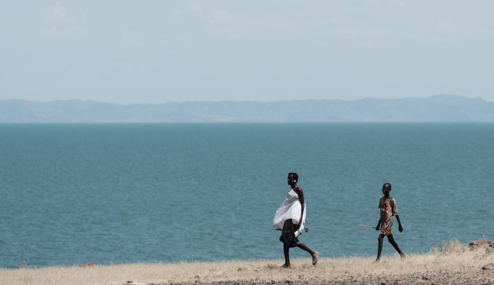 Dos personas caminan junto al lago Turkana, el mayor lago situado en un desierto del mundo, en el norte de Kenia.