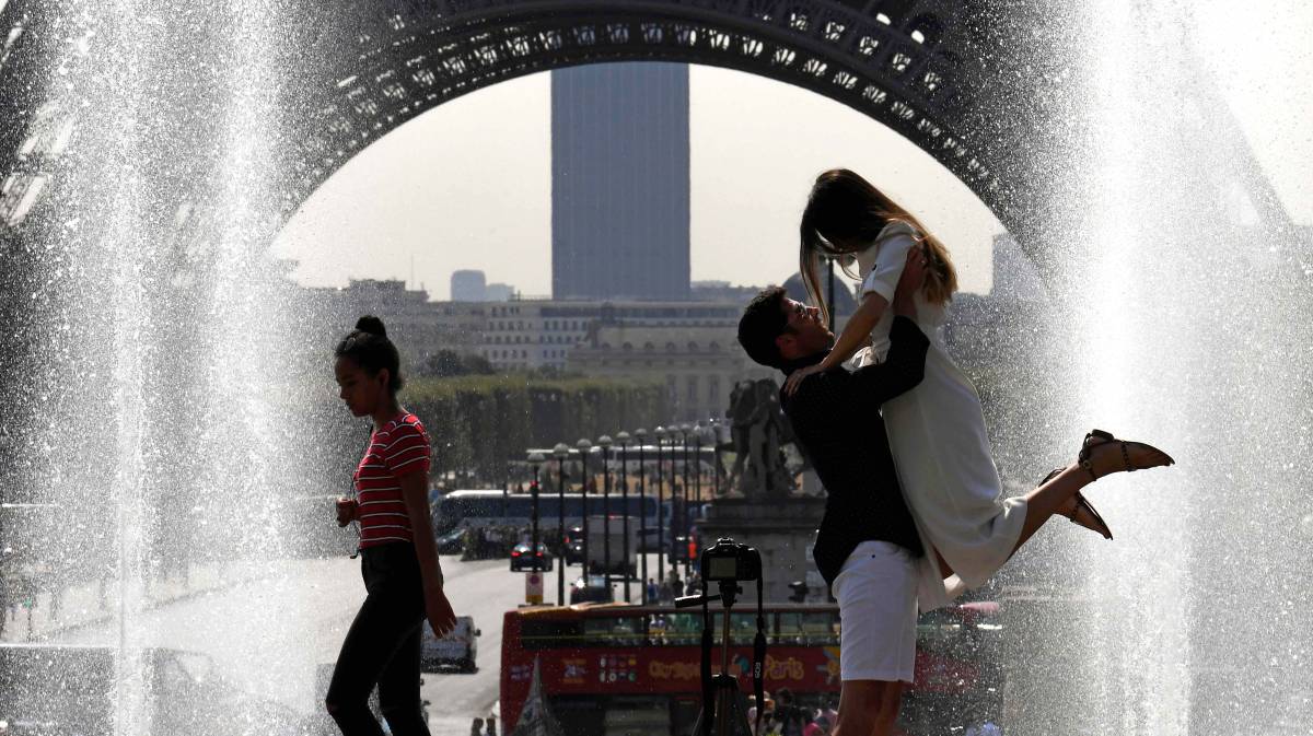 Turistas posan junto a la Torre Eiffel en ParÃ­s.