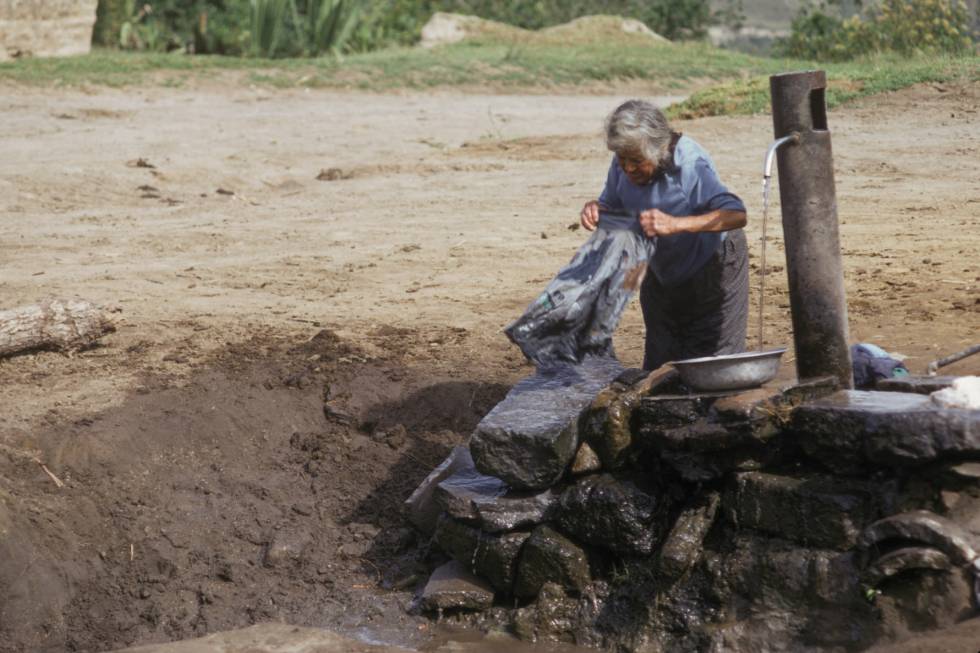 Una mujer lava ropa en el abrevadero de un pueblo en la sierra ecuatoriana. 