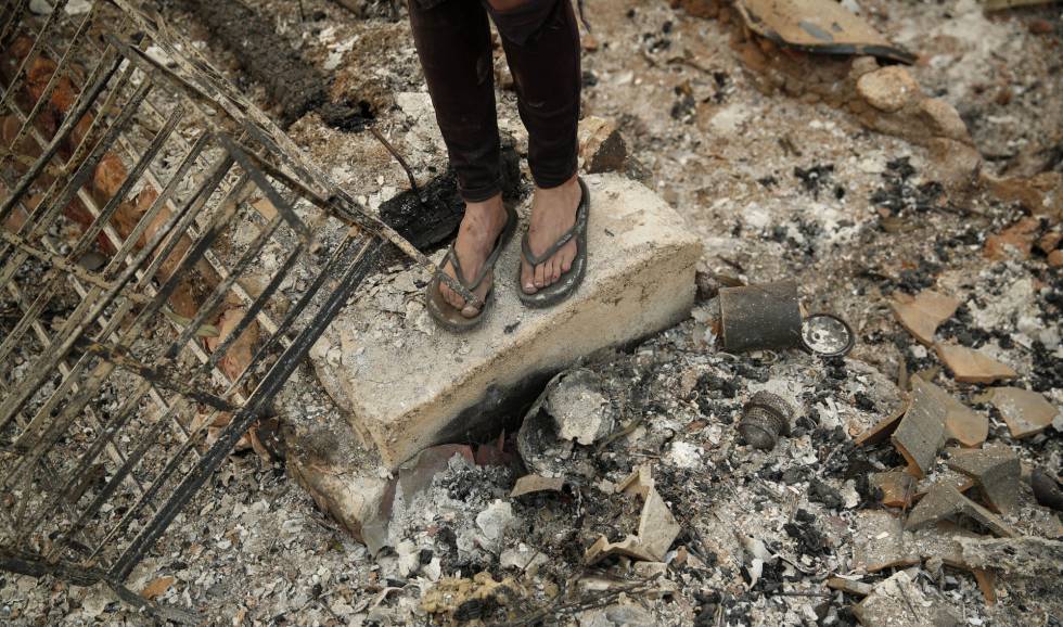 Una joven, sobre las ruinas calcinadas de la casa del novio de su madre tras los incendios en Redding (California).