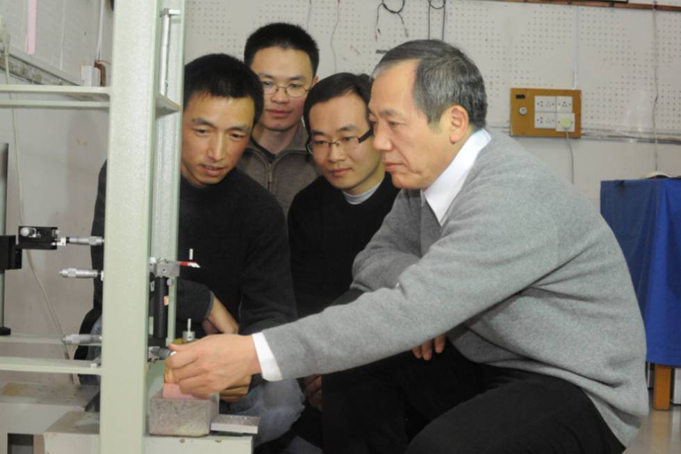 El físico Jun Luo (derecha) y su equipo, junto a uno de sus aparatos.