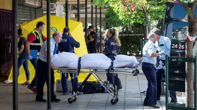 Miembros del servicio funerario trasladan el cadáver de la mujer.