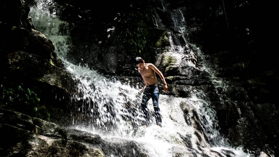 Un muchacho juega en una cascada de un nacimiento de agua en la Huasteca Potosina.