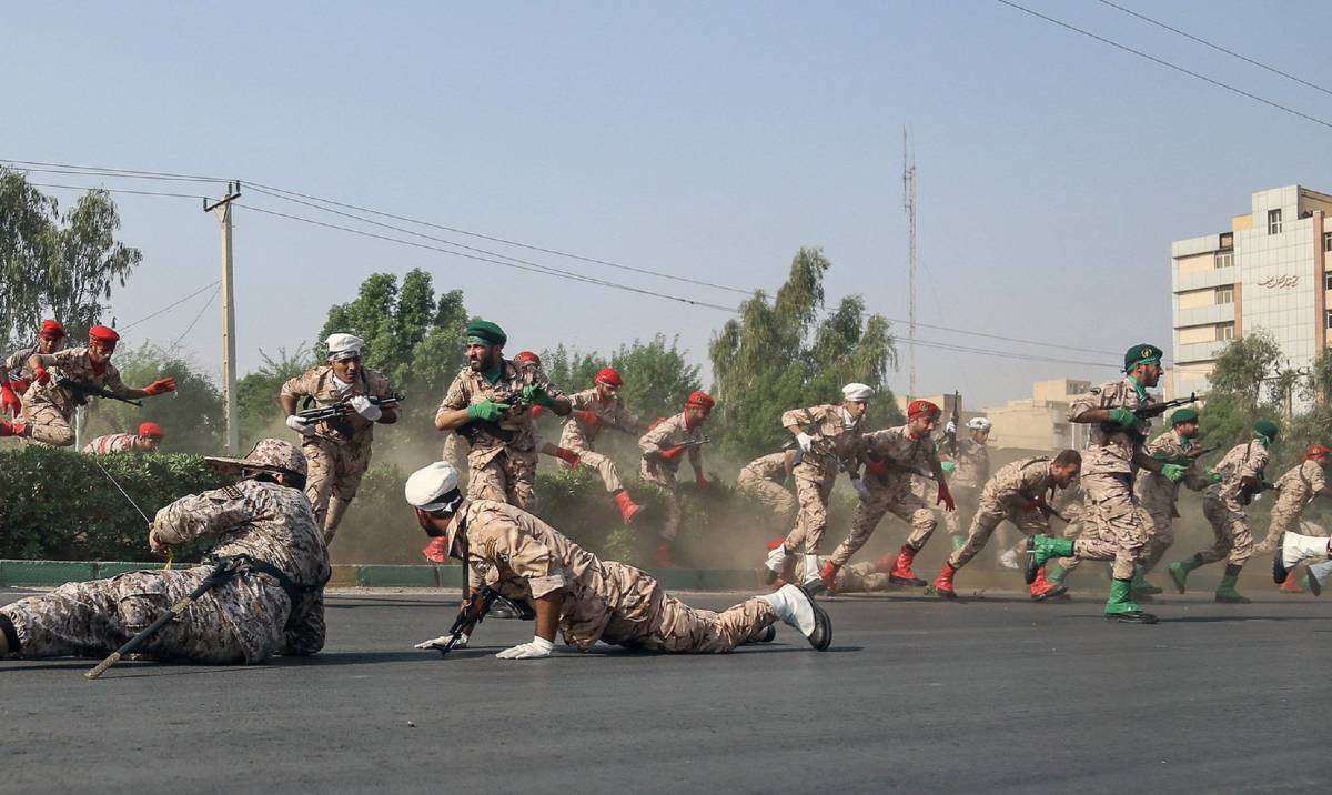 Soldados iraníes huyen a la carrera en busca de protección tras el atentado en Ahvaz.