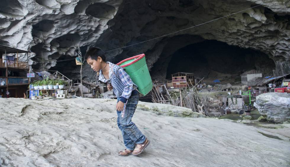 Un niÃ±o residente en la cueva de Zhongdong (China), transporta un cesto a la espalda en las afueras de la caverna. Los menores que viven aquÃ­ tienen muchas dificultades para ir a la escuela.
