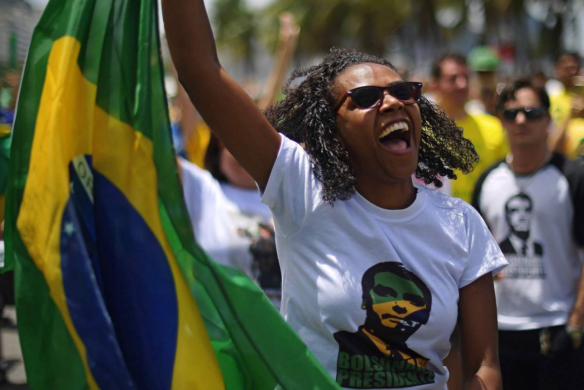 A supporter of Brazil's presidential right-far candidate Jair Bolsonaro takes part in a rally in Copacabana, Rio de Janeiro on October 21, 2018. - Counterflow to the movement against Bolsonaro, right-wing black women and gays wait anxiously for the former militaryman's accession to power. (Photo by CARL DE SOUZA  AFP)