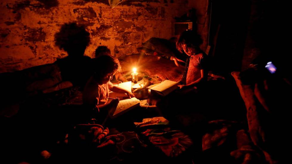 Menores hacen sus deberes durante un corte de luz en una zona empobrecida de Gaza, en 2011.