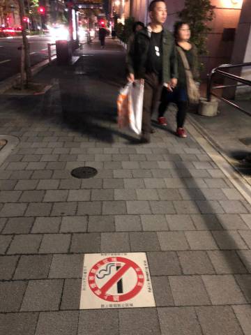 Cartaz proibindo o fumo em uma calçada do Japão.